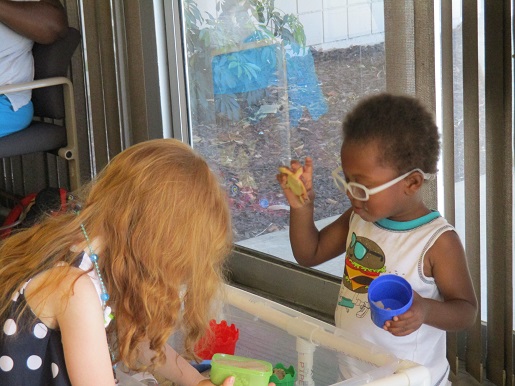 Two children exploring the tactile props used for learning.